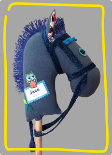 Donkerblauw stokpaardje met blauwe manen en de naam Jace op het label